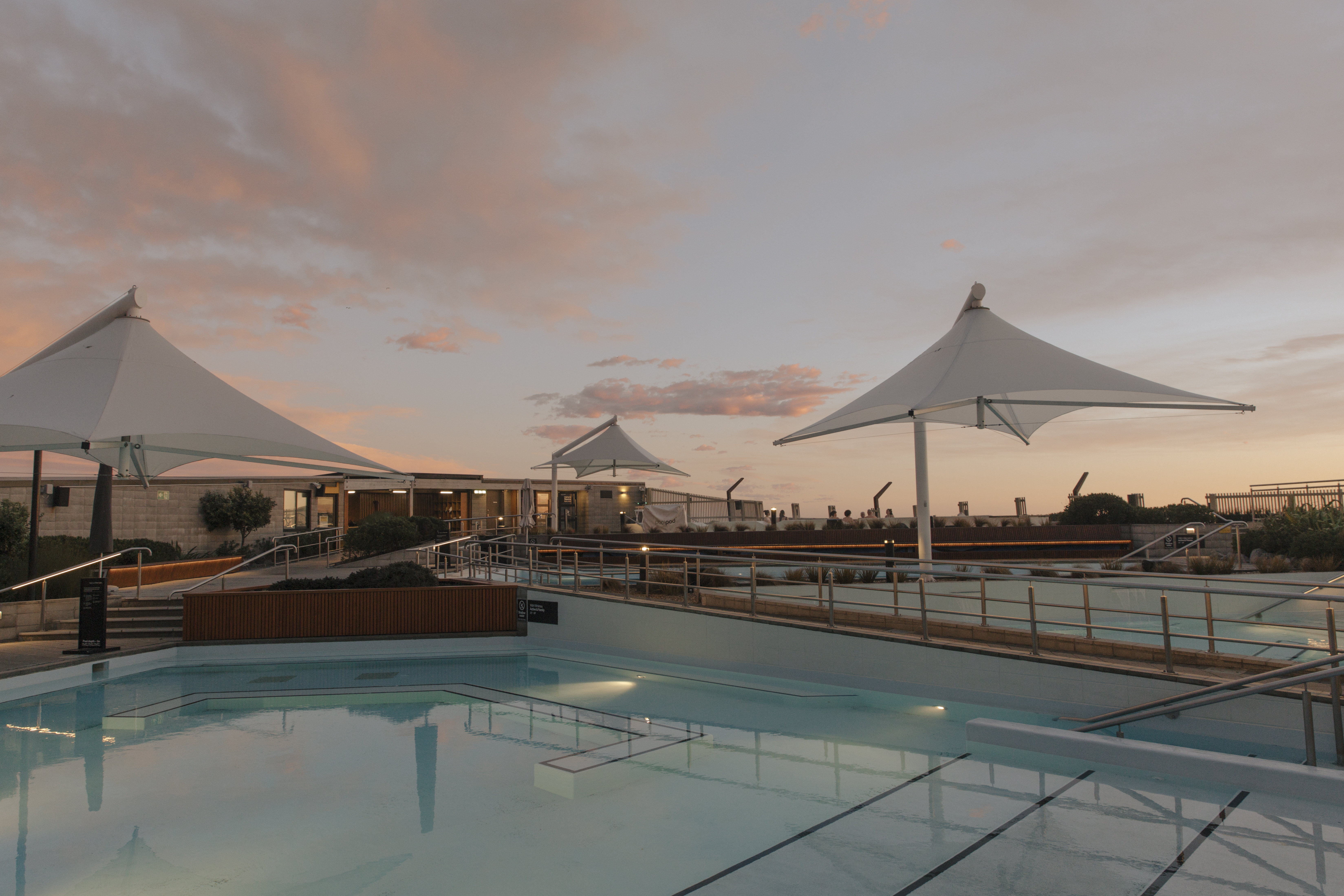 View across the hot pools under a pink evening sky