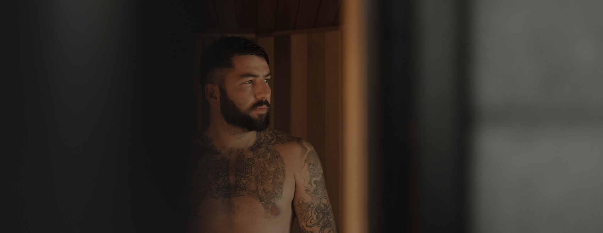 Man sitting in a sauna, looking out through a window